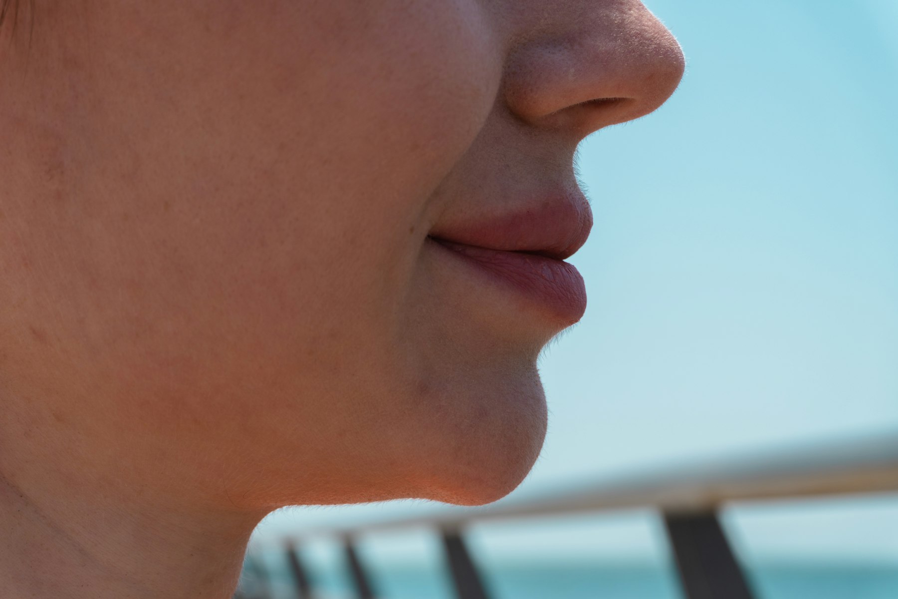 Profile close-up of the lip and chin area with calm, clear skin